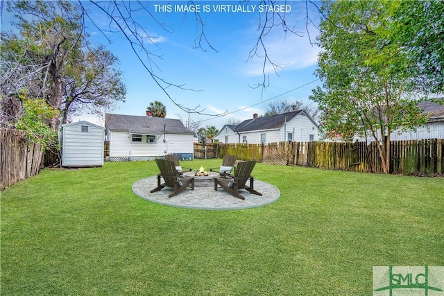 view of yard with an outdoor structure, a storage unit, a fenced backyard, and an outdoor fire pit