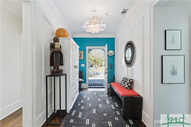 doorway to outside featuring ornamental molding and a notable chandelier