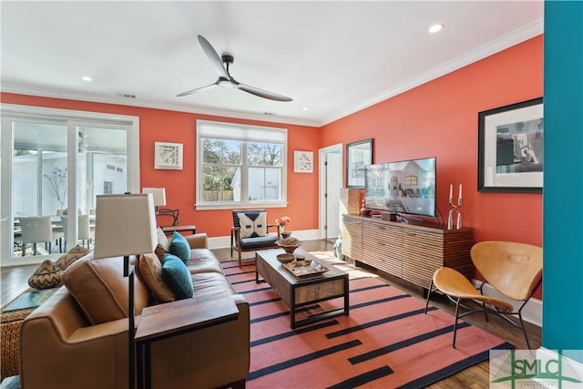 living room featuring wood-type flooring, ceiling fan, and crown molding