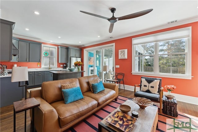 living room with crown molding, ceiling fan, and light wood-type flooring