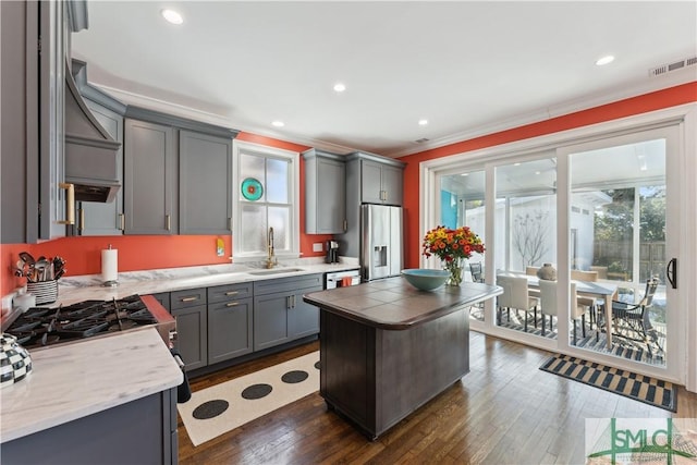 kitchen featuring sink, dark wood-type flooring, gray cabinetry, ornamental molding, and stainless steel fridge with ice dispenser