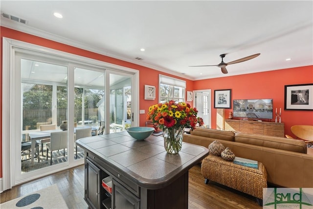 living room featuring dark wood-type flooring, ceiling fan, and crown molding