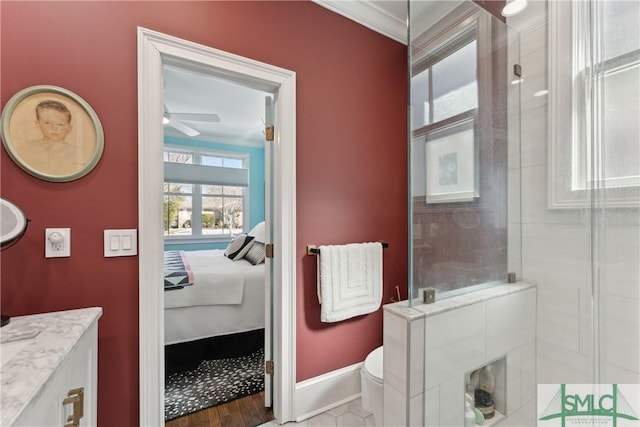 bathroom featuring a shower with shower door, vanity, ornamental molding, ceiling fan, and toilet