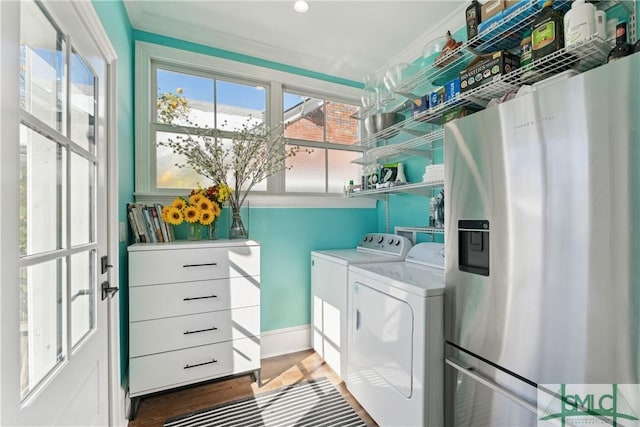 laundry room featuring crown molding, dark hardwood / wood-style floors, and washing machine and dryer