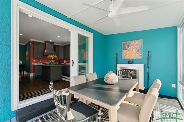 dining area featuring crown molding, dark hardwood / wood-style floors, and ceiling fan