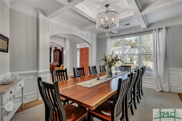 dining space featuring beamed ceiling, crown molding, coffered ceiling, and an inviting chandelier