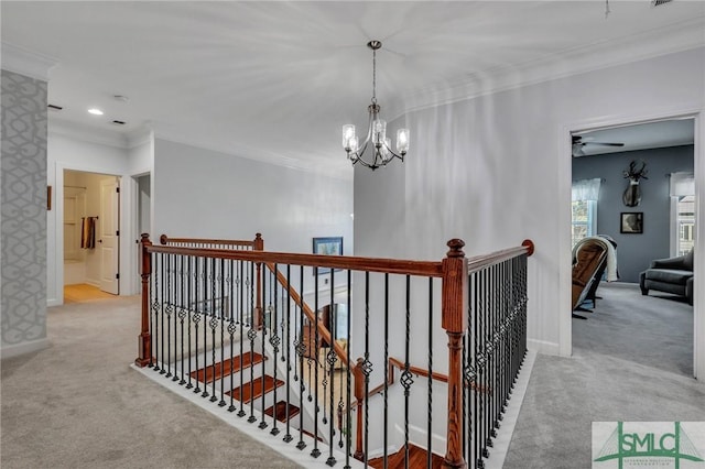 hall featuring crown molding, an inviting chandelier, and light carpet