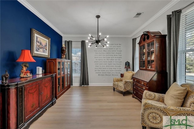 living area featuring an inviting chandelier, crown molding, and light hardwood / wood-style floors