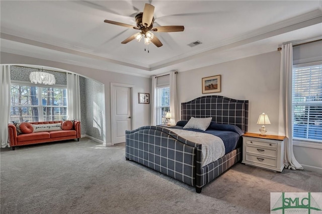 bedroom featuring a raised ceiling, crown molding, carpet, and ceiling fan with notable chandelier