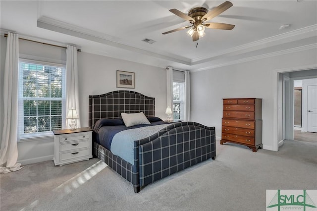 carpeted bedroom featuring multiple windows, a tray ceiling, and ceiling fan