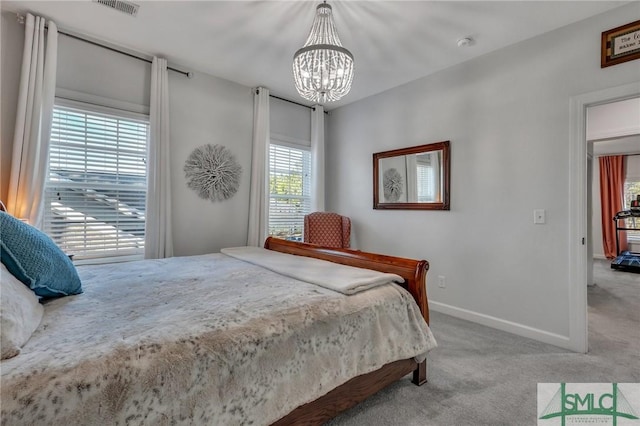 bedroom featuring an inviting chandelier and light colored carpet