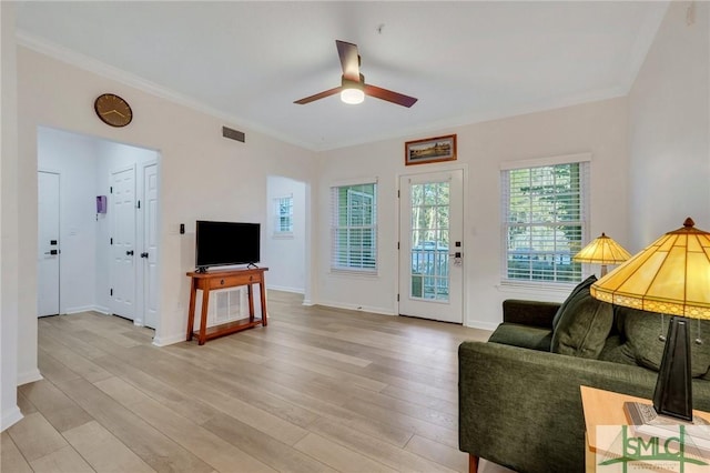 living room featuring crown molding, light hardwood / wood-style floors, and ceiling fan