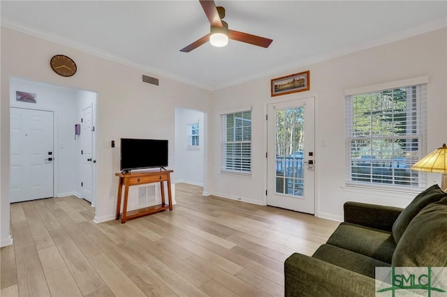 living room with crown molding, light hardwood / wood-style flooring, and ceiling fan