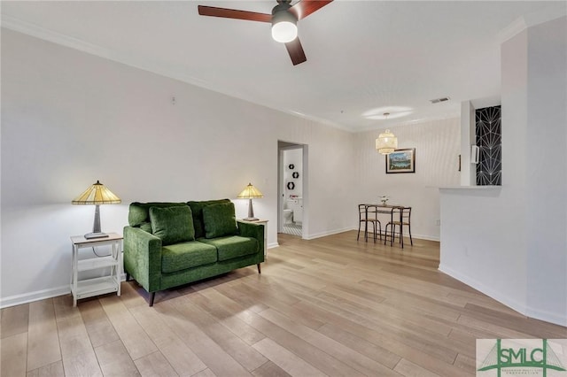 interior space featuring ceiling fan, ornamental molding, and light wood-type flooring