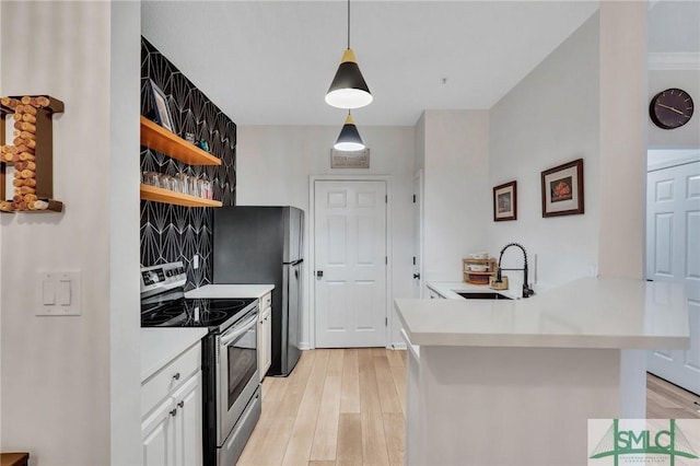 kitchen with sink, white cabinets, hanging light fixtures, kitchen peninsula, and stainless steel appliances