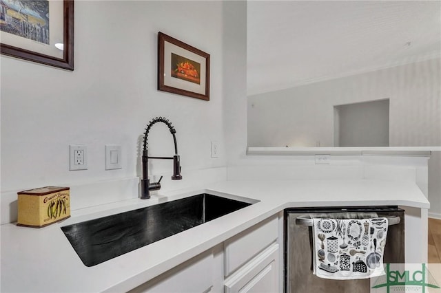 kitchen with dishwasher, sink, white cabinets, and kitchen peninsula