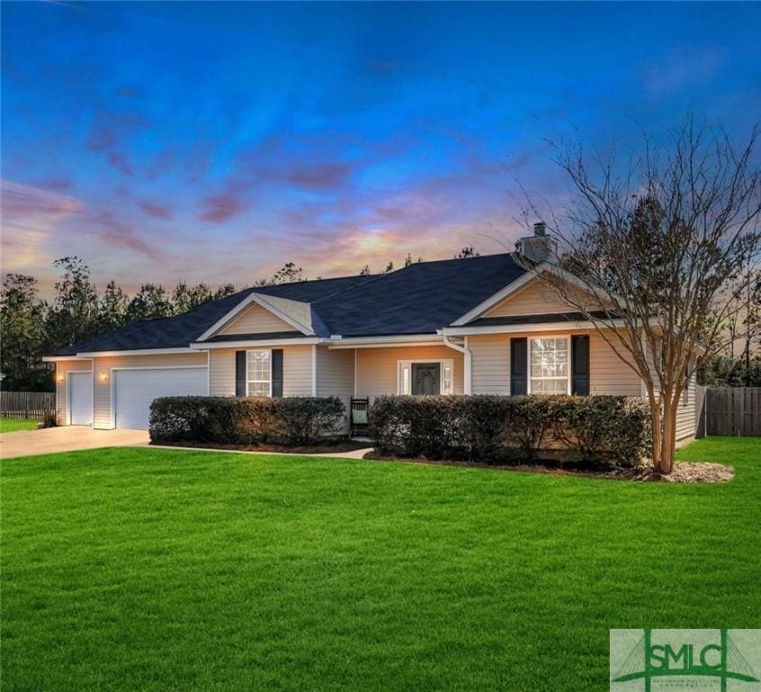 ranch-style home with a garage and a lawn