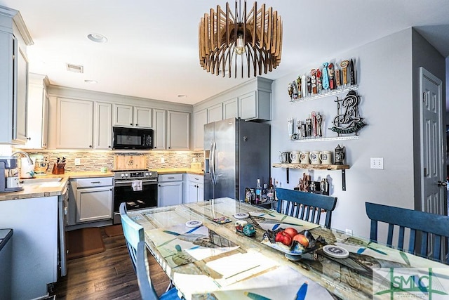 kitchen featuring wood counters, sink, appliances with stainless steel finishes, dark hardwood / wood-style flooring, and backsplash