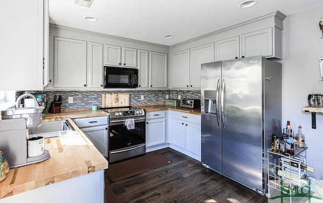 kitchen featuring appliances with stainless steel finishes, dark wood-type flooring, white cabinets, and wood counters