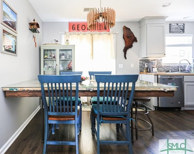 dining area featuring dark wood-type flooring and sink