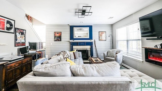 living room featuring wooden walls and a fireplace