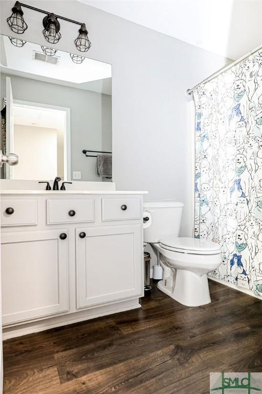 bathroom featuring vanity, hardwood / wood-style floors, and toilet