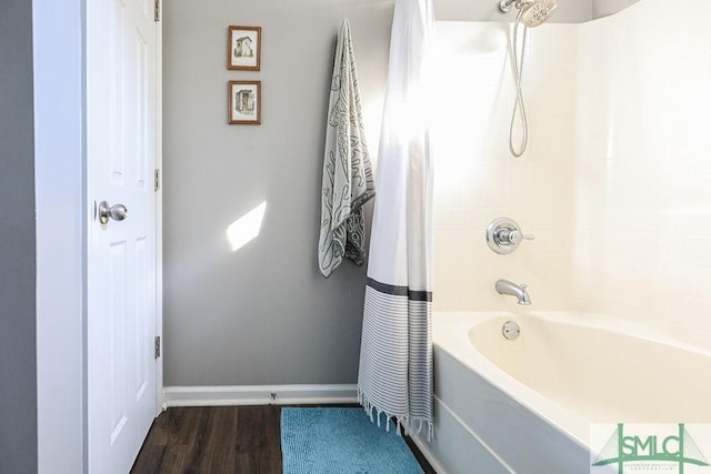 bathroom featuring hardwood / wood-style flooring and shower / bathtub combination with curtain