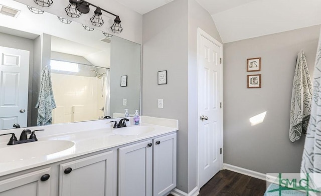 bathroom featuring lofted ceiling, vanity, hardwood / wood-style flooring, and a shower with shower curtain