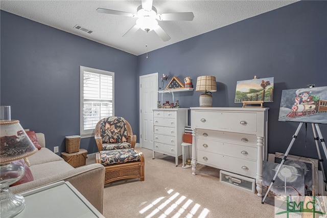 interior space featuring a textured ceiling, carpet floors, and ceiling fan