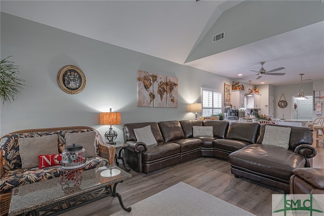 living room with wood-type flooring, ceiling fan, and vaulted ceiling