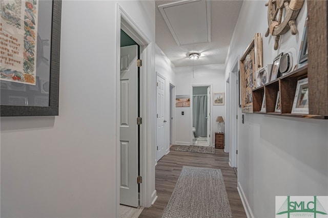 hall featuring wood-type flooring and a textured ceiling