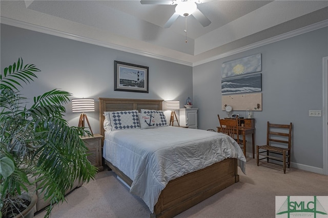 bedroom featuring crown molding, ceiling fan, a tray ceiling, and light carpet