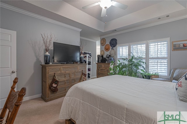 bedroom with a raised ceiling, light colored carpet, and ceiling fan