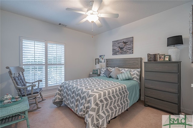 bedroom with ceiling fan, light carpet, and multiple windows