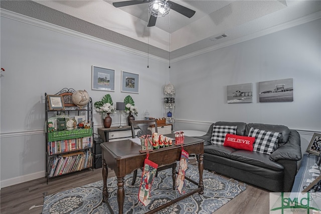 home office with crown molding, dark hardwood / wood-style floors, ceiling fan, and a tray ceiling