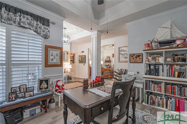 office area featuring light hardwood / wood-style flooring, ceiling fan, decorative columns, ornamental molding, and a textured ceiling