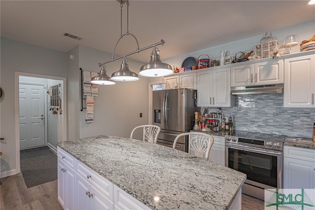 kitchen featuring stainless steel appliances, white cabinetry, tasteful backsplash, and light stone counters