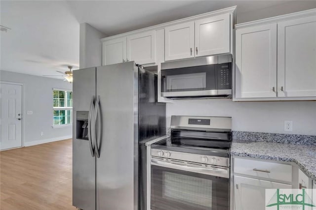 kitchen featuring stainless steel appliances, light stone countertops, white cabinets, and ceiling fan