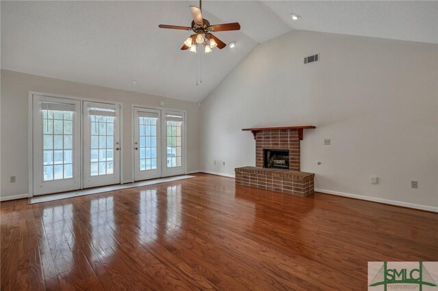 unfurnished living room with ceiling fan, wood-type flooring, a brick fireplace, and lofted ceiling