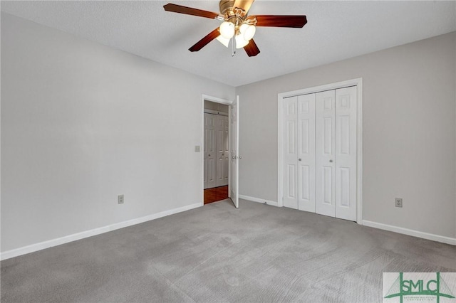 unfurnished bedroom featuring carpet flooring, a textured ceiling, ceiling fan, and a closet