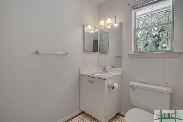 bathroom with vanity, toilet, tile patterned flooring, and a wealth of natural light