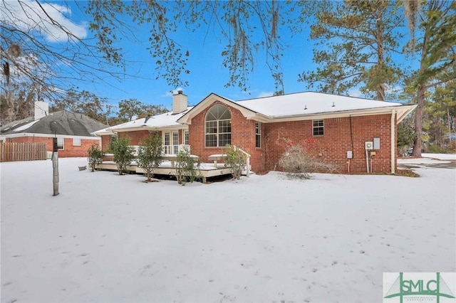 snow covered property with a wooden deck