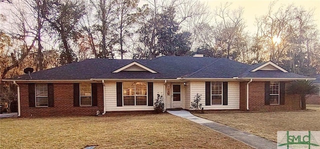 single story home featuring a front yard and brick siding