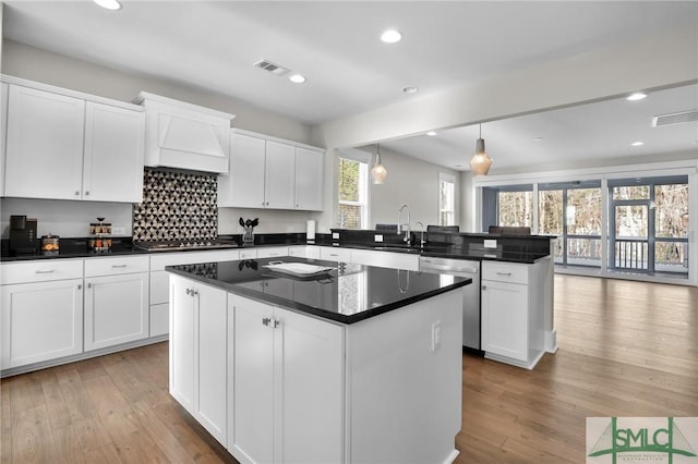 kitchen with stainless steel appliances, a kitchen island, and white cabinets