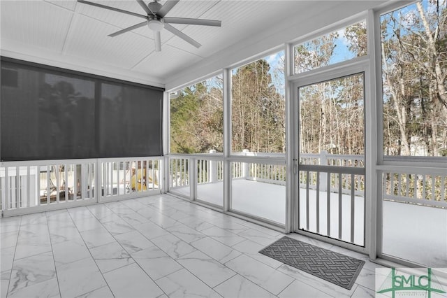 unfurnished sunroom with ceiling fan