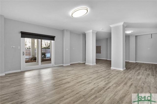 unfurnished living room with decorative columns and light wood-type flooring