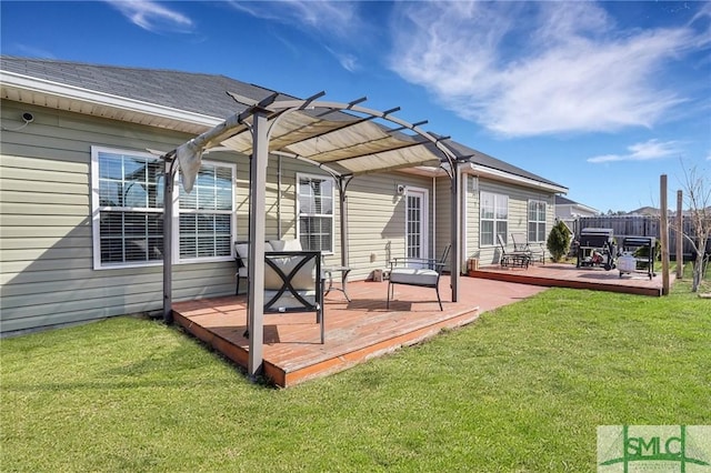 rear view of property with a yard, a pergola, and a deck