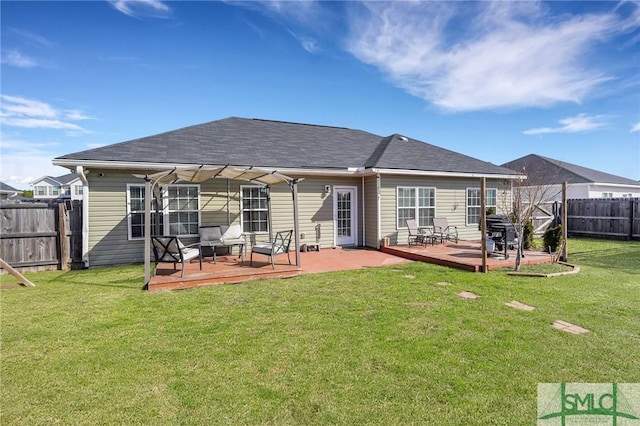 rear view of property with a wooden deck and a lawn