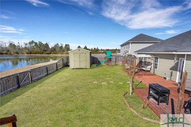 view of yard featuring a water view, a storage unit, and a playground