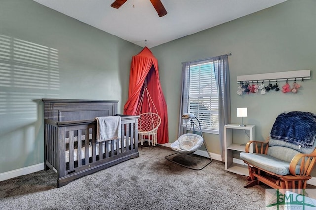 bedroom featuring a nursery area, ceiling fan, and carpet